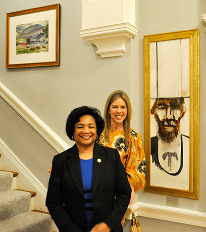 Deux femmes debout à côté d'un portrait contemporain d'Abraham Lincoln.