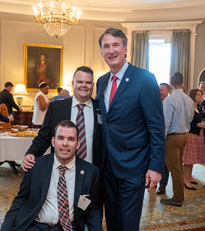 Le gouverneur pose avec deux hommes dans l'Executive Mansion.