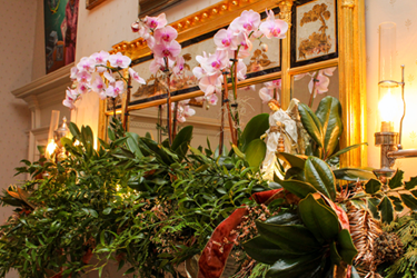 Orchidées en fleurs dans une couronne sur la cheminée