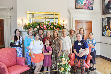 La première dame pose avec un groupe de femmes dans le salon des dames de l'Executive Mansion lors de la Journée des jardins historiques.