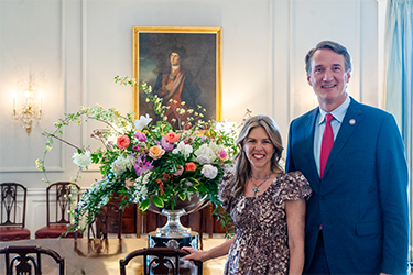 Le gouverneur et la première dame posent avec l'arrangement de la table de la salle à manger.