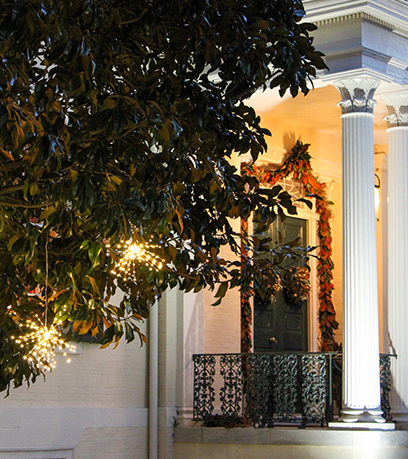 Des lumières ressemblant à des étoiles sont suspendues à un magnolia à l'extérieur de la façade de l'Executive Mansion de Virginie.