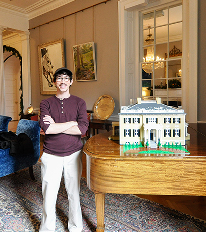 Benjamin Edlavitch debout avec sa maquette LEGO de l'Executive Mansion.