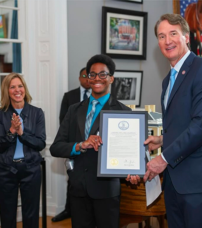 un jeune homme recevant un certificat du gouverneur