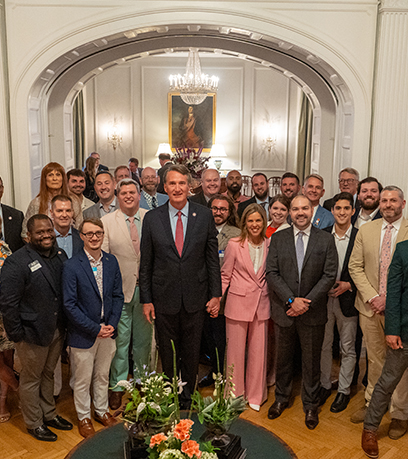 Le gouverneur et la première dame posent avec un groupe dans la salle de bal de l'Executive Mansion.