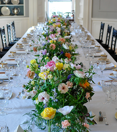 La table à manger de l'Executive Mansion est dressée avec une nappe blanche, de la porcelaine d'État et des fleurs.