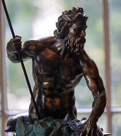 une statue en bronze du roi Neptune éclairée par la lumière naturelle d'une fenêtre de l'Executive Mansion.