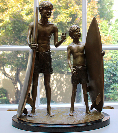 Une sculpture de deux jeunes surfeurs