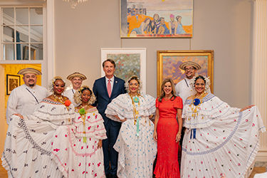 Un groupe vêtu d'habits traditionnels pose avec un homme et une femme habillés de manière formelle.
